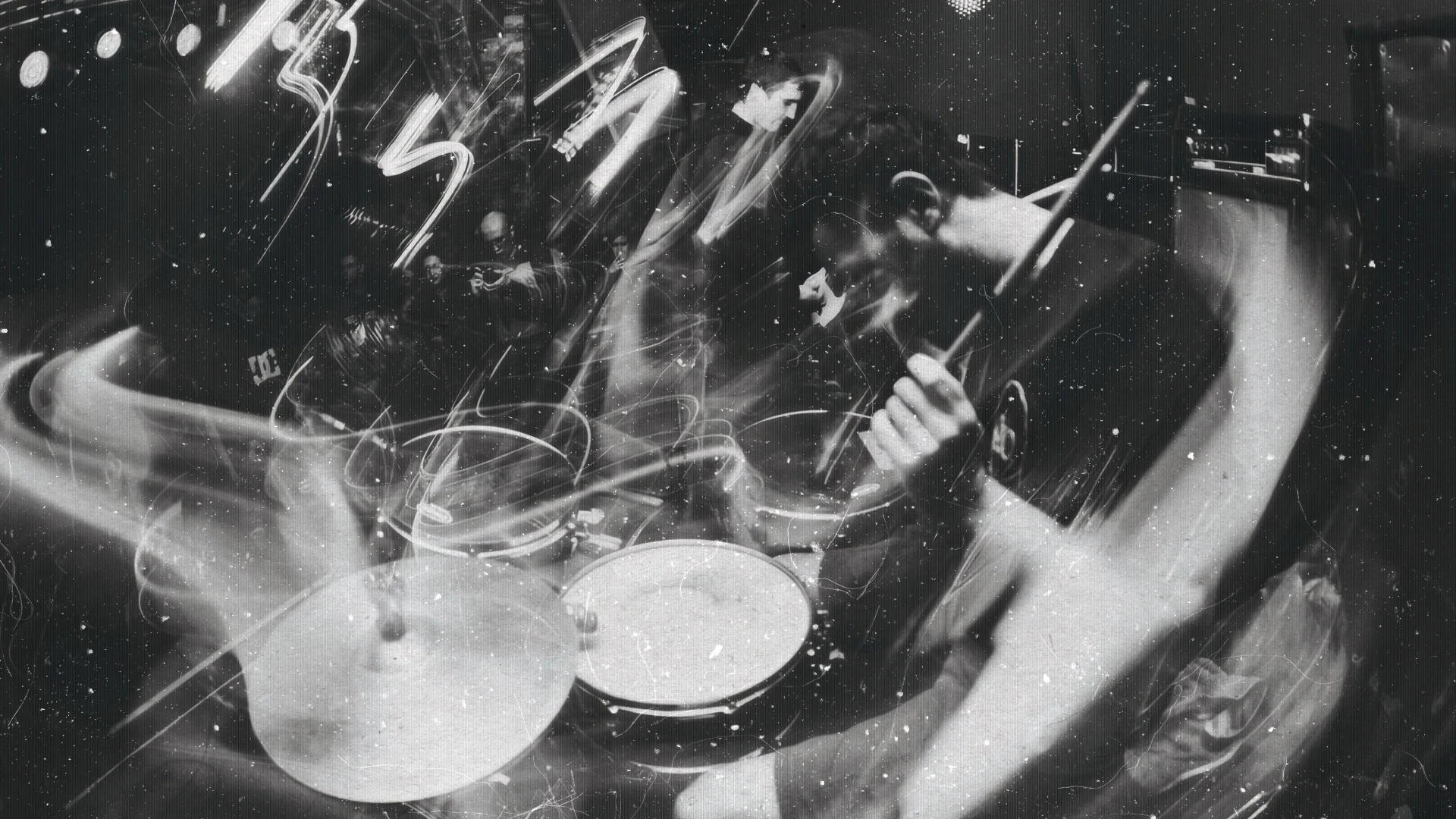 Baterista tocando nun concerto, en branco e negro